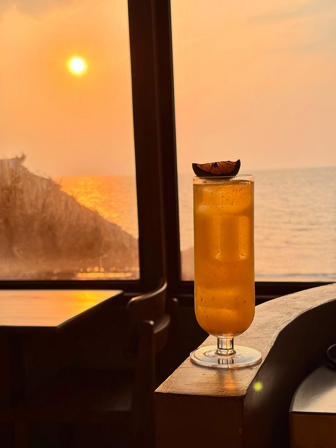 Cocktail with dehydrated citrus at sunset overlooking the sea
